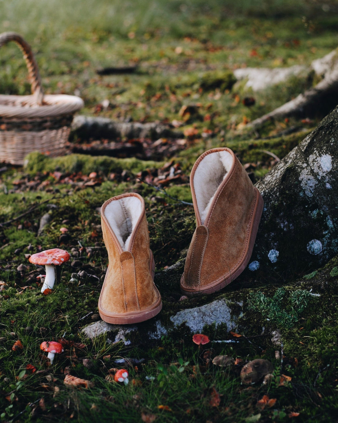 Pair of brown suede slippers on a stone surface with a natural background