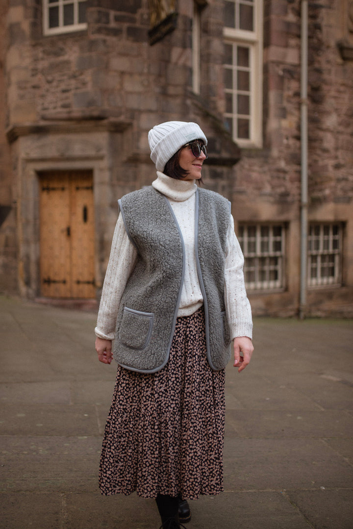 Full-length view of a woman wearing a grey wool gilet with front zip and pockets