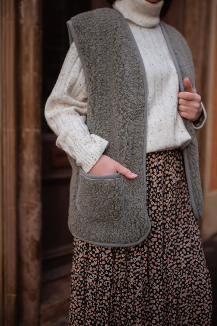 Close-up of grey wool gilet showing fleece edging and front pocket
