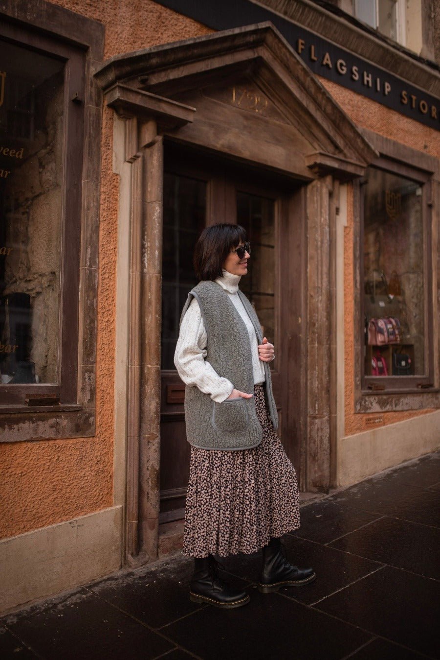 Woman wearing a grey wool gilet outdoors with a cream jumper and long skirt